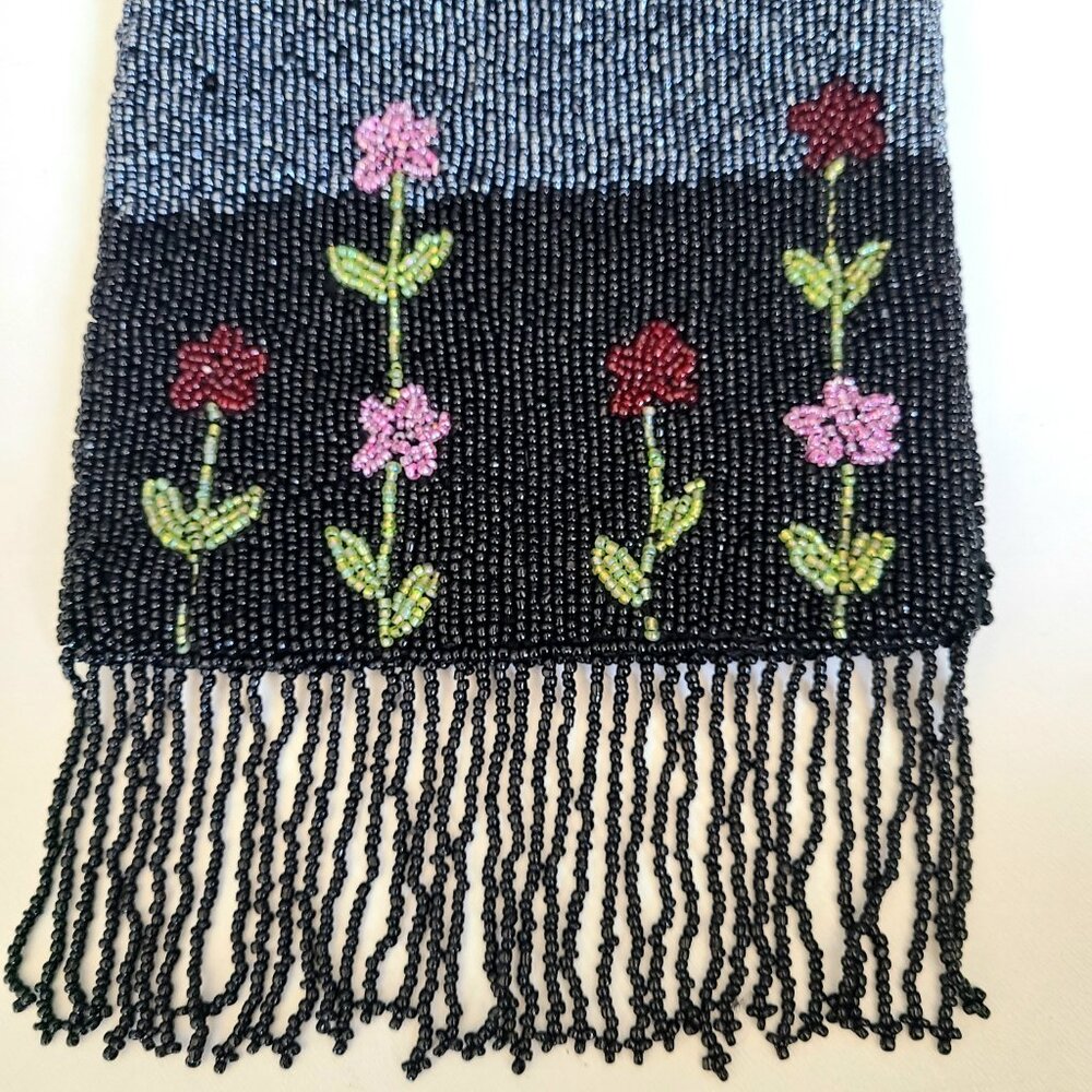 Black and silver beaded wrist bag with floral design and fringes.